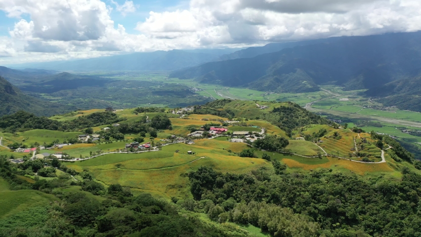 View from a flower farm of orange daylilies (Hemerocallis) on the hillside of Liushidan Mountain (六十石山), overlooking the East Rift Valley on a sunny summer day in Fuli Township, Hualien County, Taiwan