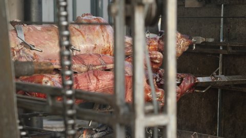 Whole pig and sheep roasting on a spit