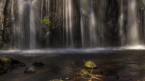 Waterfall With Lights and Shadows Rocks in the River