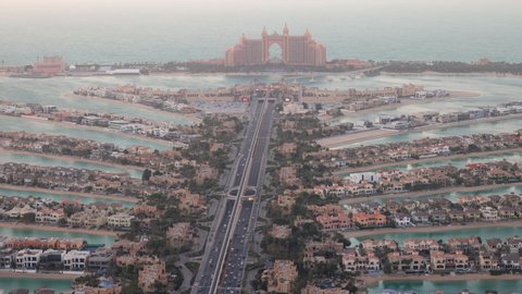 The Atlantis hotel on the Palm Jumeirah Islands in Dubai with traffic moving on the roads and monorail moving past the Pointe Mall on the branches of man made island in Dubai, UAE