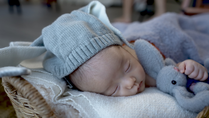 Cute Asian newborn baby. wearing a blue rabbit Sleep well. By hugging the rabbit doll. lying in a wicker basket. 10-Bit 4:2:2 25f
