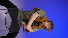 The man actively gestures with his hands. Studio with blue light. A yellow scarf on a middle-aged man. - Powered by Shutterstock - Get 15% off with code: PIKWIZARD15