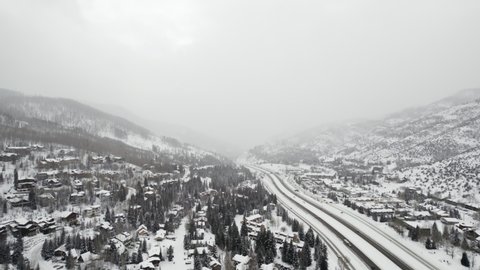 Aerial Drone Footage Flying Over Snow Covered I-70 Grand Army of the Republic Highway near Vail Colorado USA During Cold White Winter.