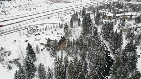 Donovan Pavilion Wedding Venue. Aerial Drone Footage Flying Over Building Surrounded By Snow Covered Pine Trees in Vail Colorado USA During Winter.