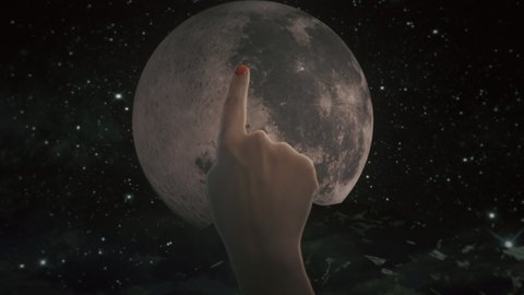 Finger Touch Turn On Full Moon Moonlight. Female finger touches the dark moon to light it up over the mountains