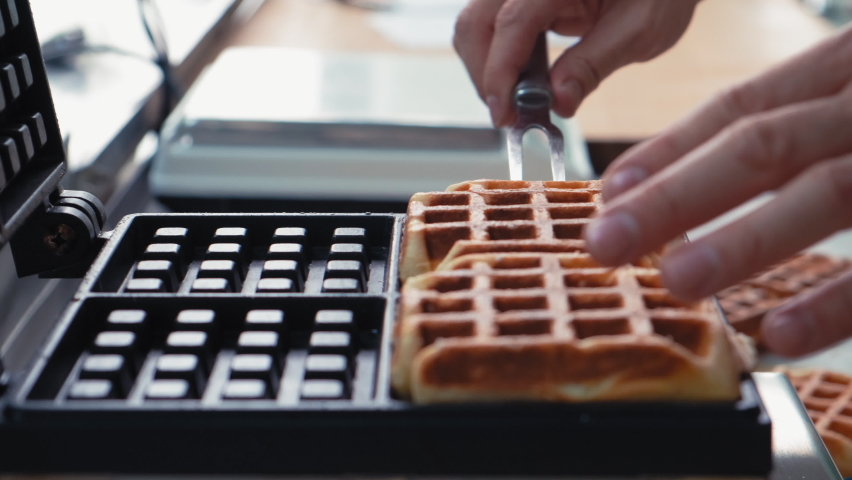 Close-up chef pours waffle batter in a waffle iron in a professional kitchen. Waffle making at the hotel with all-inclusive meals. belgian waffles in a waffle iron | Shutterstock HD Video #1086719969