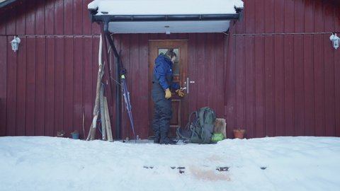 Man Open The Woodes Door Of Cabin Then Put A Leash On Alaskan Malamute. - static