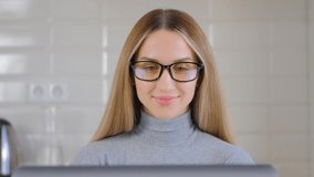 Happy white woman working on laptop at home during lockdown. Portrait of pretty Caucasian female using computer for distant work online. Freelancer person works on notebook pc in closeup 4k video