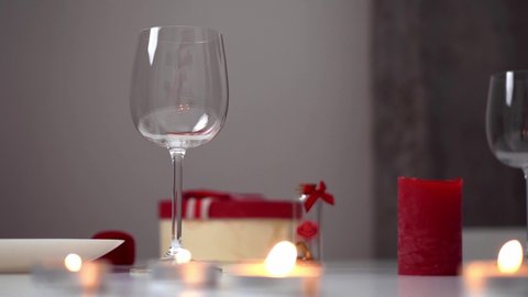 A man's hand pours wine. Wine is poured into a glass from a bottle. Valentine's day romantic dinner. red candles red wine valentine's day
