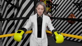 Young business woman in a white suit and boxing gloves in a boxing ring - Powered by Shutterstock - Get 15% off with code: PIKWIZARD15