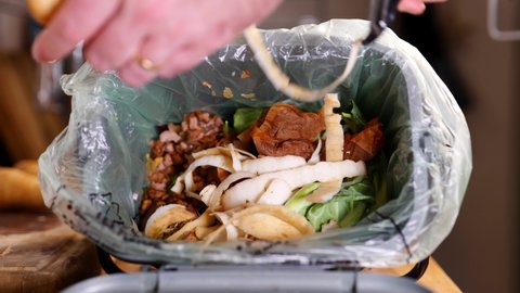 Peeling a parsnip into a food waste bin