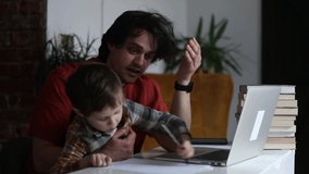 Father working with a son in home office at laptop