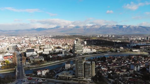 Aerial Timelapse Shot of Traffic In Skopje over the Vardar river With The Skopska Crna Gora Mountains In The Background on a Sunny Day