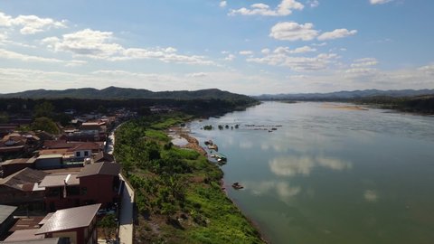 Aerial footage towards the horizon over the Mekong River and the Walking Street in Chiang Khan across is Laos, Loei in Thailand.