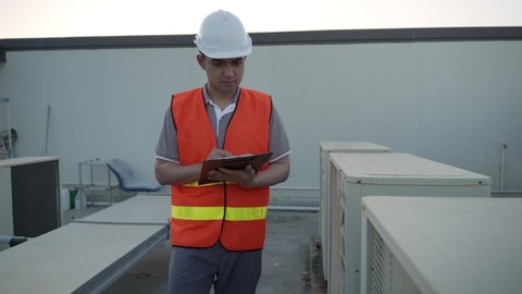 check and inspect. Inspector or engineer walking recheck refrigeration system of the factory and system operation. Maintenance operator test the air conditioning system on the roof deck of the factory