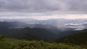 Majestic view of the rain clouds over the mountain landscape. Location place Carpathian mountains, Ukraine, Europe. Cinematic shot. Filmed in UHD 4k video. Time lapse footage. Beauty of earth.