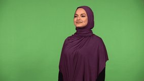 A young beautiful Muslim woman stretches - green screen background