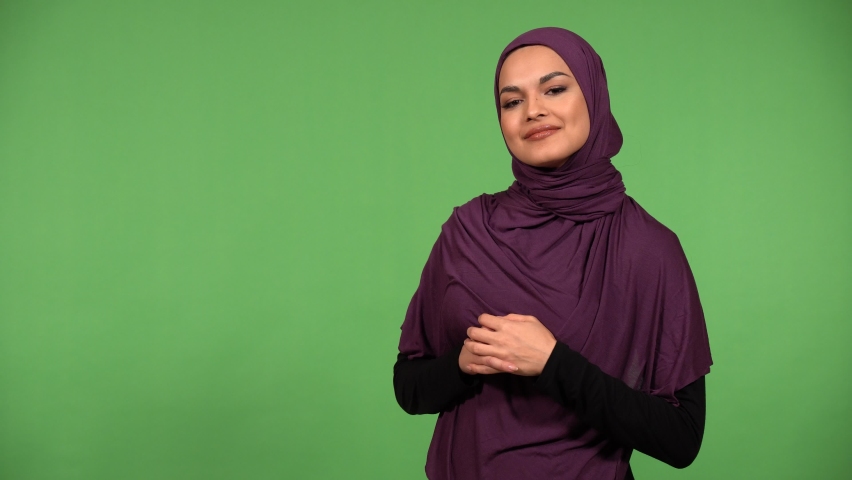 A young beautiful Muslim woman talks to the camera with a smile - green screen background Royalty-Free Stock Footage #1086762176