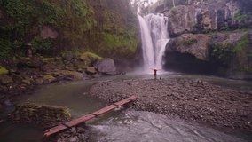 Travel people explore beautiful destination Bali, Waterfall Tegenungan hidden in tropical rain forest jungle. 4K 