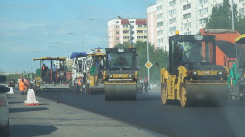 Samara, Russia - July 13, 2021: Road works, pavers and rinks on the road. View through the windshield of the car