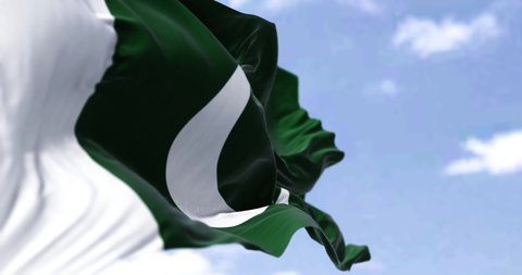 Detail of the national flag of Pakistan waving in the wind on a clear day. Democracy and politics. Patriotism. Selective focus. South Asian country. Seamless slow motion