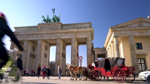 THE BRANDENBURG GATE, PARISER PLATZ, BERLIN, GERMANY – 18 FEBRUARY 2019, People, cyclists, tourists horse and carriage during the day by The Brandenburg Gate, Pariser Platz, Berlin, Germany