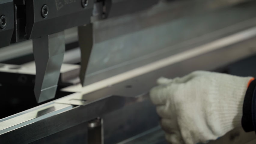 Operator places a metal sheet on a machine that folds it slowly on each side to create Rectangular Tube. Automated Metal folding and Bending Machine. Manufacturing Process. Precise Machining. Close up | Shutterstock HD Video #1086772241