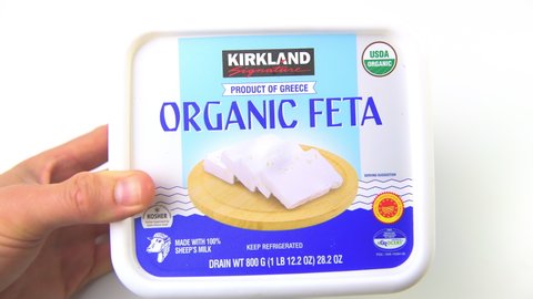 Naples, USA - October 27, 2021: Closeup of hand holding product of Greece Kirkland Costco brand of sheep milk feta cheese dairy in brine with USDA organic sign label