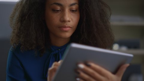 Entrepreneur african american woman using tablet computer researching data in office. Close up young female business worker surfing internet web on tab in remote workplace. Manager corporate concept.