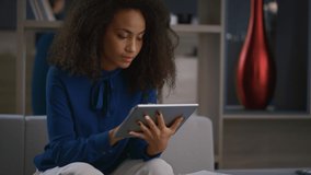 Calm african american entrepreneur woman working tablet drinking coffee in home office. Young business lady using touchpad digital tab in workplace. Boss girl browsing internet. Remote work concept. - Powered by Shutterstock - Get 15% off with code: PIKWIZARD15