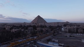 Drone video of the Giza pyramids at sunrise, construction cranes and building sites. Cairo - Egypt