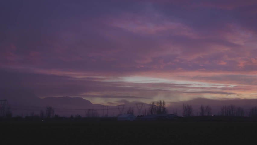 Farm lands and Canadian Mountain Nature Landscape. Dramatic Winter Sunset. Located near Chilliwack and Abbotsford, British Columbia, Canada.
