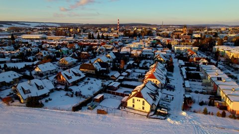 Aerial drone video showing a scenic view of a town covered with thick white layers of snow in winter. Snow covered the landscape at sunrise.