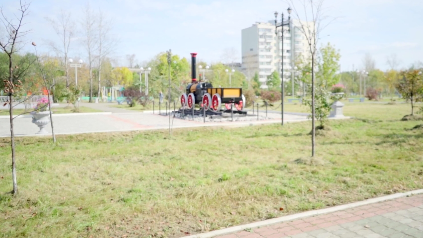 An old steam locomotive on a pedestal. A real old steam locomotive. It is installed near the House of Culture of Railway Workers in the city of Khabarovsk. In the Far East of Russia. 