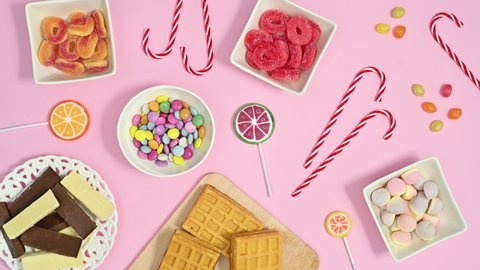 6k Pastel pink theme full with sweets, candies, lollypops and chocolates moving. Stop motion flat lay