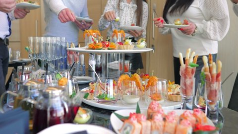 Meals for a group of people, buffet in a luxury office, close-up. The business team enjoys a break at work, are treated to canapes snacks.Business lunch.Beautifully decorated banquet table.catering