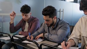 Frames movement group diverse young students sit in row at desk in classroom concentrated write test answers or essay make notes on paper taking exam higher education concept at university or school - Powered by Shutterstock - Get 15% off with code: PIKWIZARD15