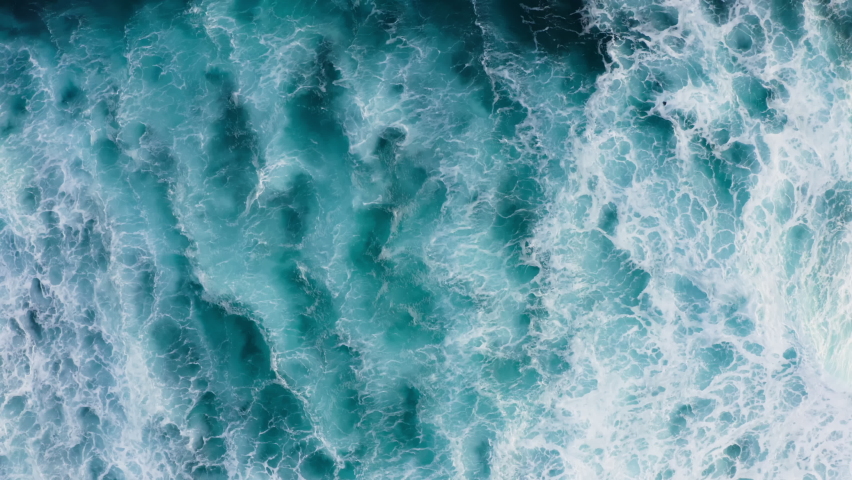 Beautiful texture of big power dark ocean waves with white wash. Aerial top view footage of fabulous sea tide on a stormy day. Drone filming breaking surf with foam in Indian ocean. Big swell in Bali. Royalty-Free Stock Footage #1086820415