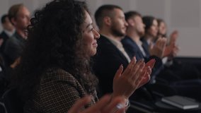 Group of people applauds to speech at business conference. Stage talk at summit meeting in crowded modern hall. Mixed race woman training at economic forum. Applause of female person in suit closeup - Powered by Shutterstock - Get 15% off with code: PIKWIZARD15