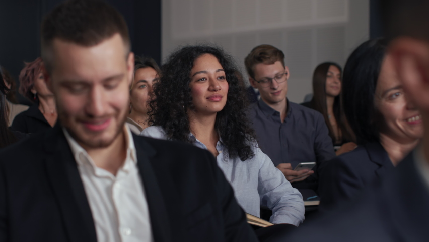 Group of people listens speech at business conference. Stage talk at summit meeting in crowded modern hall. Mixed race woman training at economic forum. Business work of sitting female person indoors | Shutterstock HD Video #1086821444