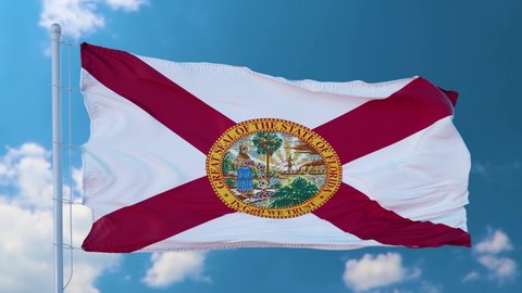 Florida flag on a flagpole waving in the wind in the sky. State of Florida in The United States of America