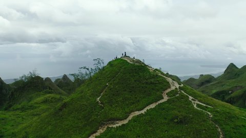 Amazing green Lugsangan Peak between an hilly landscape on a cloudy day in the Badian Heights in the province Cebu in the Philippines. Drone panning shot