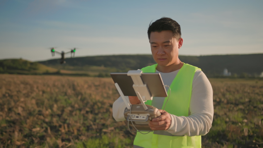Professional asian farmer specialist with tablet computer controlling black drone to monitor harvest condition. Agricultural field. Innovationes in agribusiness. Royalty-Free Stock Footage #1086838736