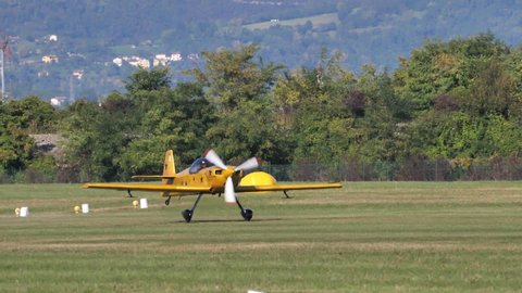 Thiene Vicenza Italy OCTOBER, 16, 2021 Mudry CAP 231: Yellow aircraft with black star ready to takeoff. Aircraft taxiing on the runway. The big powerful engine of yellow plane rotating. Slow-motion. 