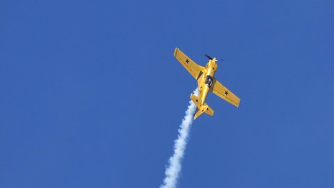 Thiene Vicenza Italy OCTOBER, 16, 2021 Yellow airplane moves vertically upward releases aerobatics smoke from behind. Aerobatics acrobats in slow-motion. Mudry CAP 231 by Andrea Pesenato