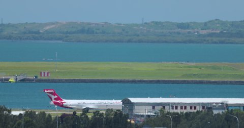 Sydney, Australia - circa the 2020s, Qantas Boeing 737 taxis in front of the Control tower at Sydney International airport. High-quality 4k footage. Tourism, travel, and commercial jets.