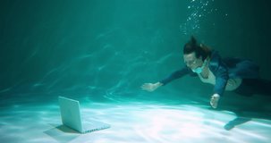 CLIENT SUPPORT CONCEPT Young beautiful business woman dives under water to use laptop webcam video call slow motion.