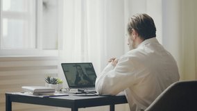 Male doctor having online video consultation with female patient, distance work