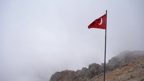Turkish flag on top of a mountain in the fog