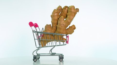 Natural ginger in a grocery cart on a white background, ginger is spinning on a table